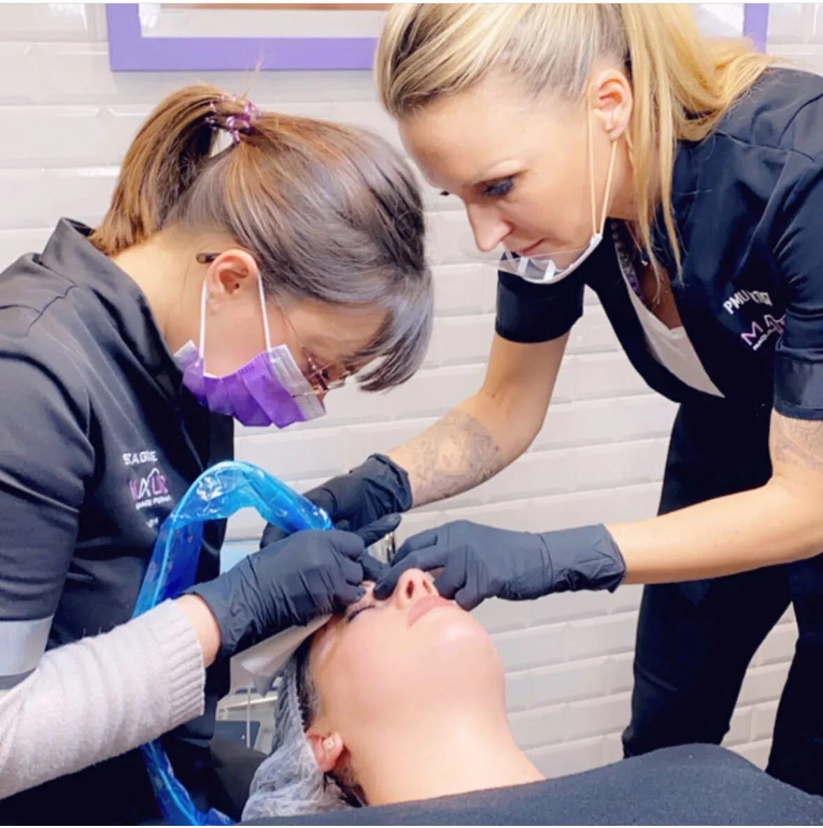 Élève réalisant un eye-liner sous la supervision d'une formatrice Maud Academy
